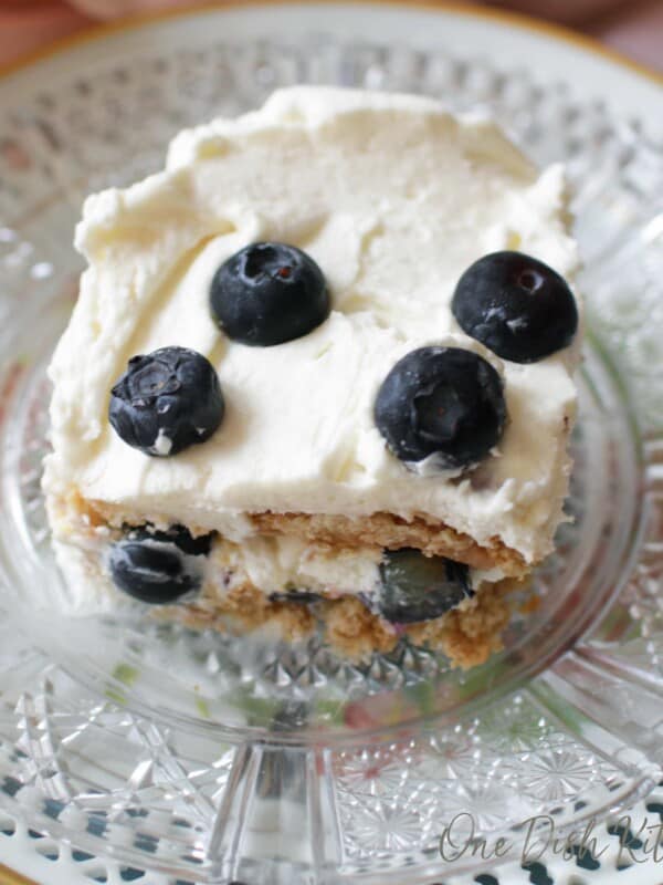 slice of icebox cake with blueberries on glass plate
