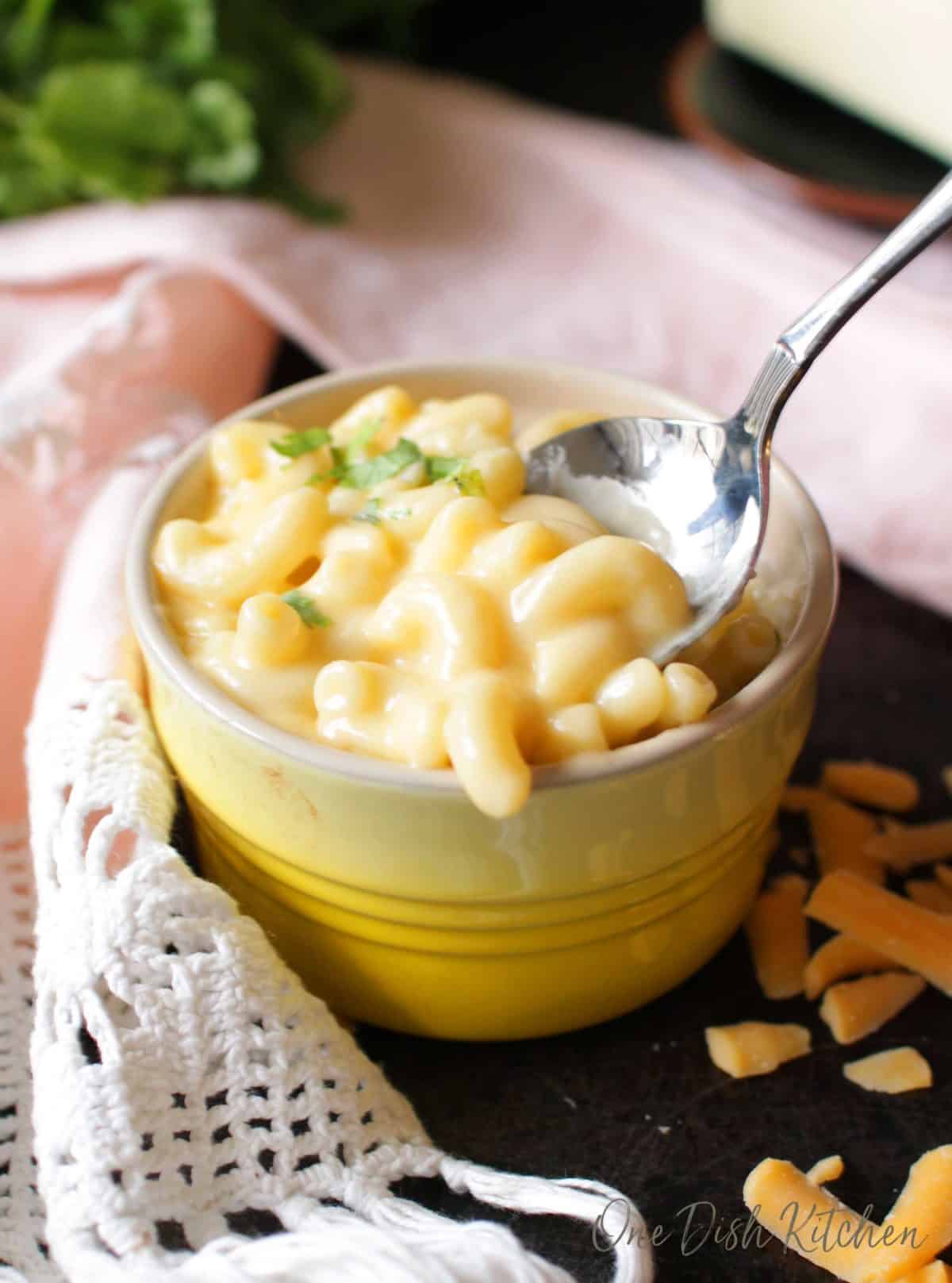A spoonful of macaroni and cheese from a small bowl 