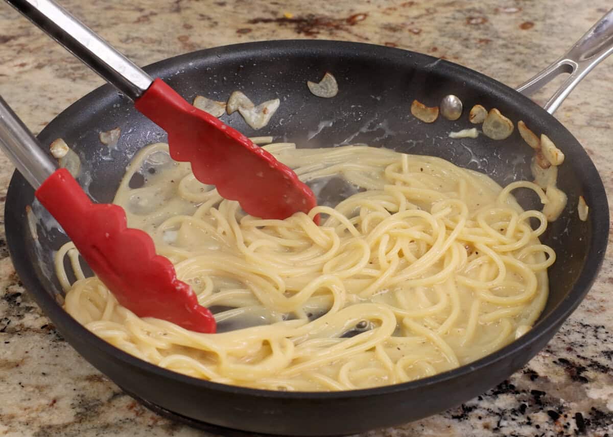 cooking pasta carbonara in a skillet.