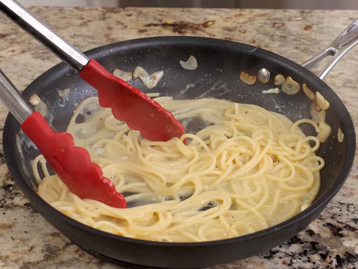 cooking pasta carbonara in a skillet.