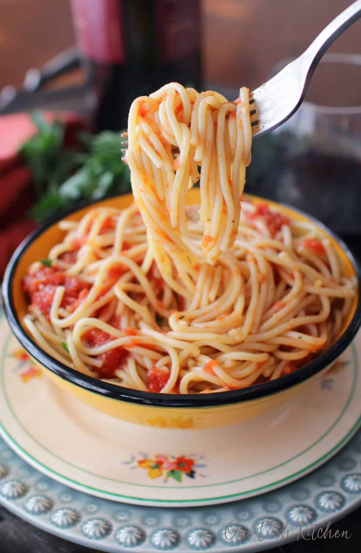 A closeup of spaghetti hanging from a fork.