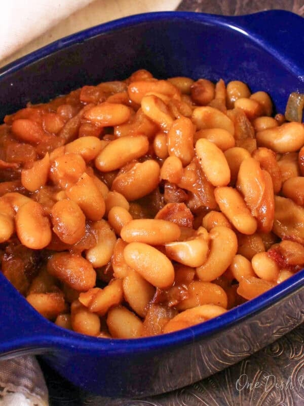 a single serving of baked beans in a blue dish on a silver tray.
