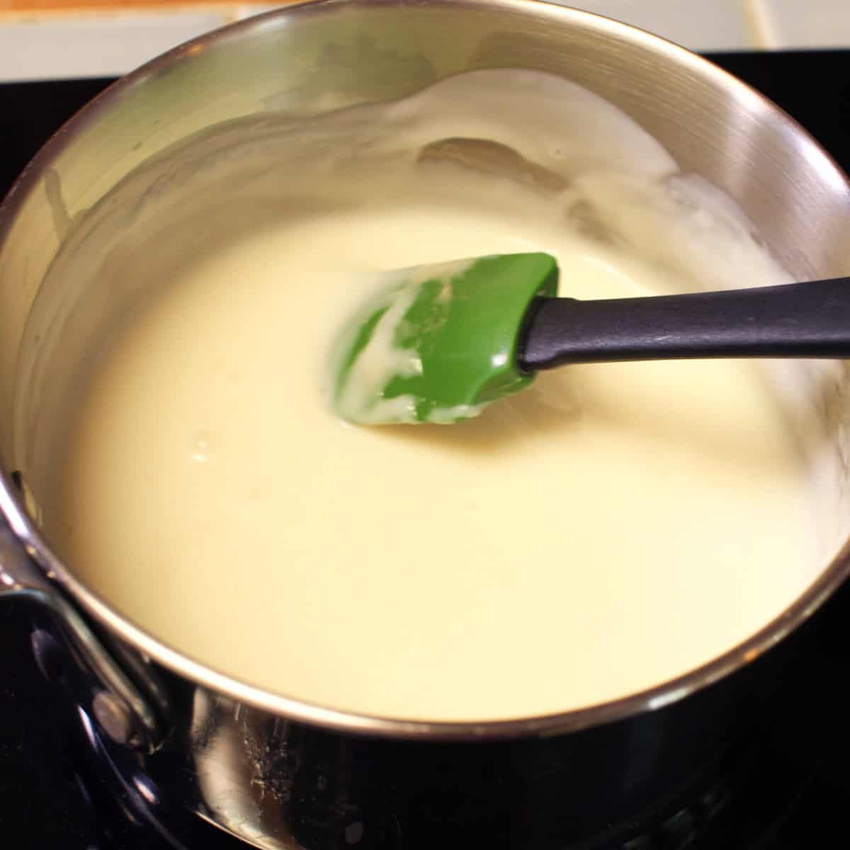 vanilla pudding for banana cream pie simmering in a pot.