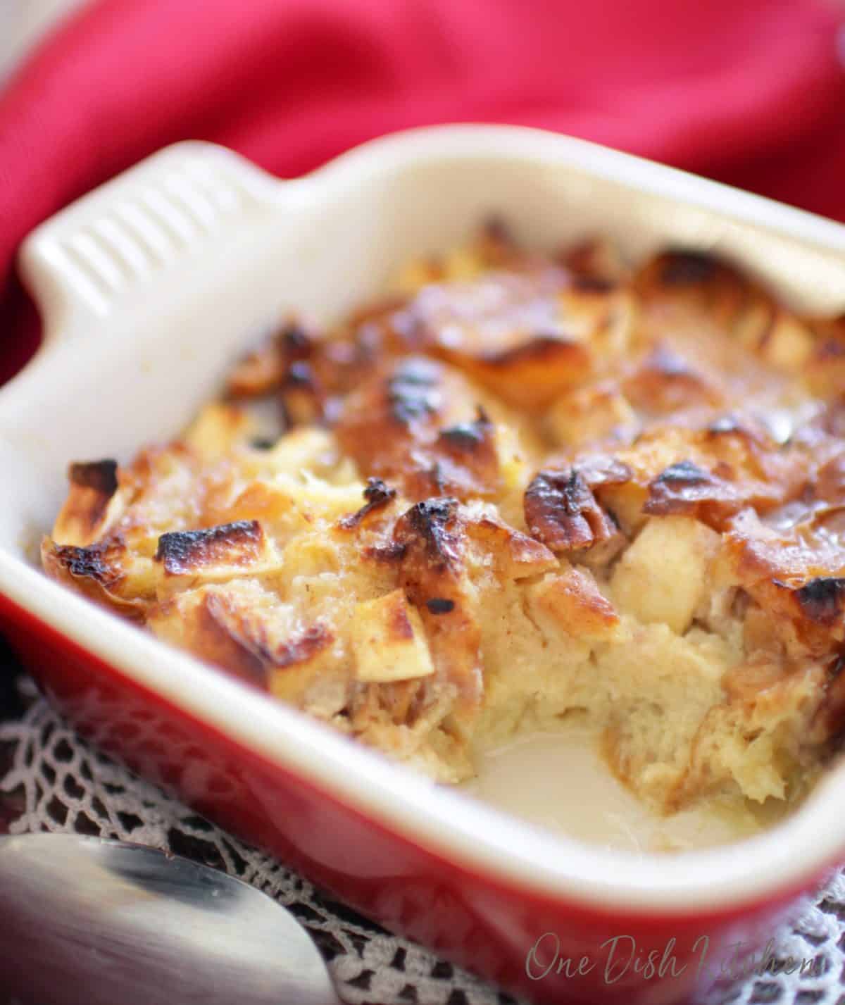 A partially eaten breakfast bread pudding made with bits of croissants on a tray.