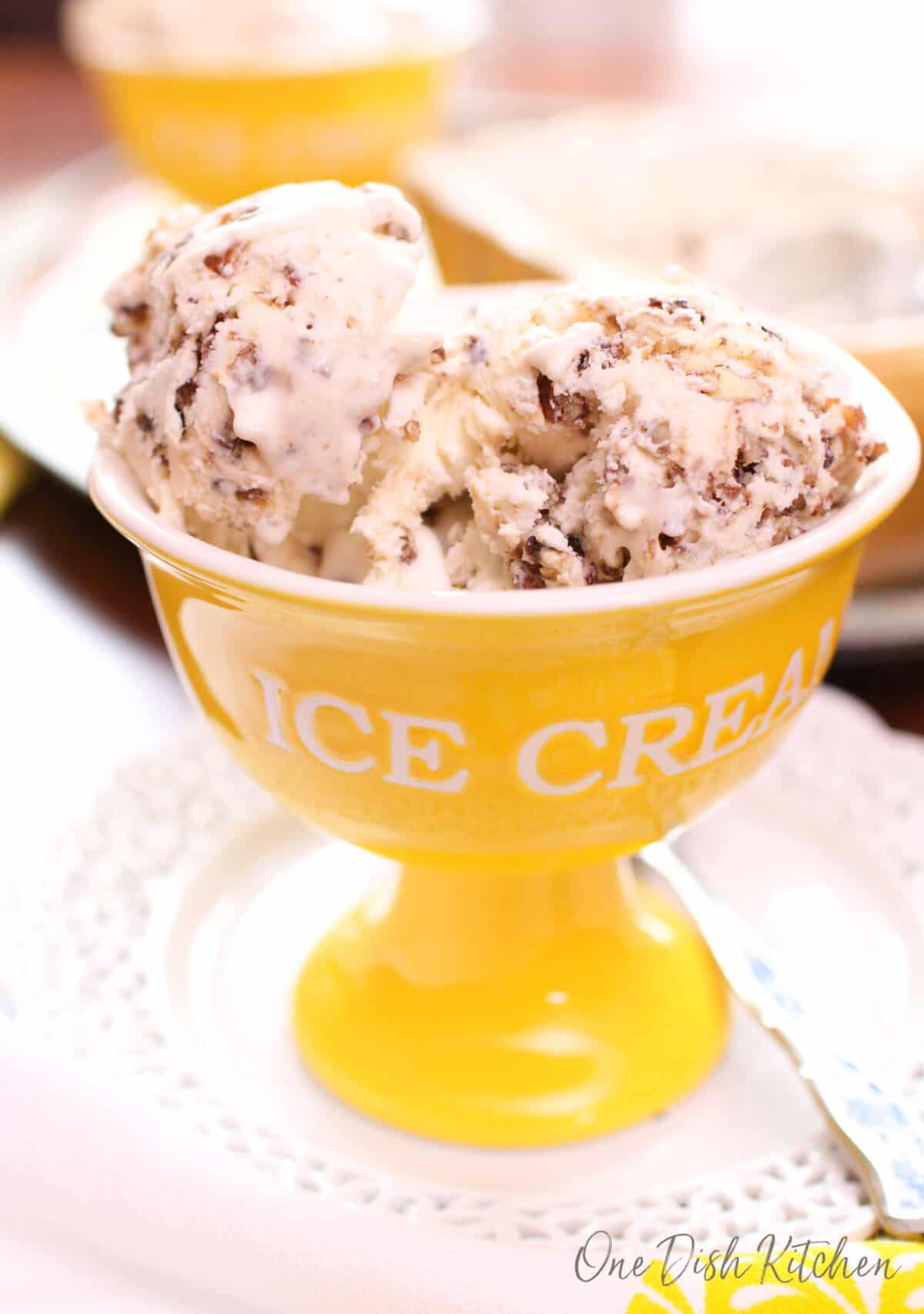 a yellow bowl filled with butter pecan ice cream.