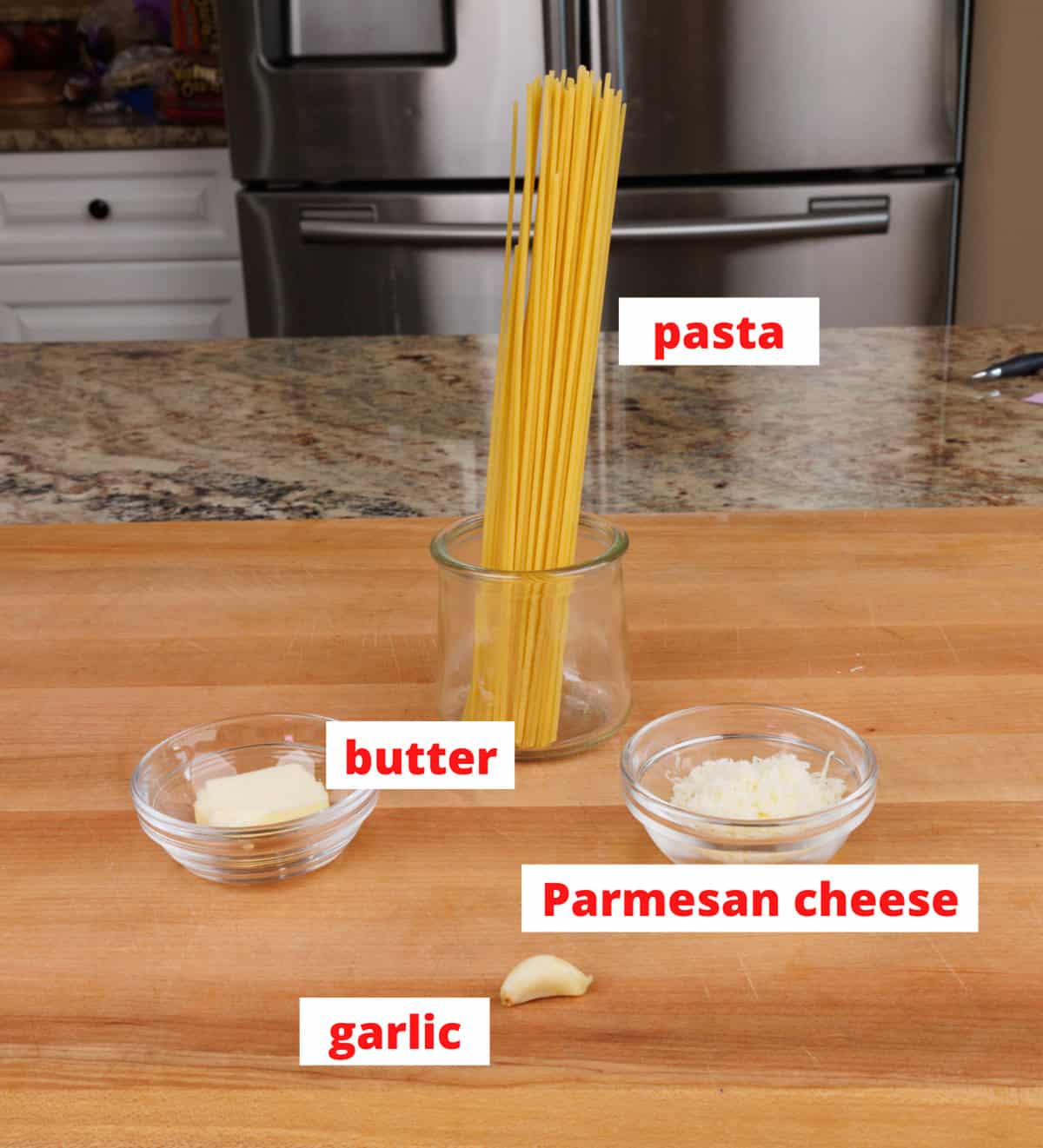 buttered noodles ingredients on a wooden cutting board in a kitchen.