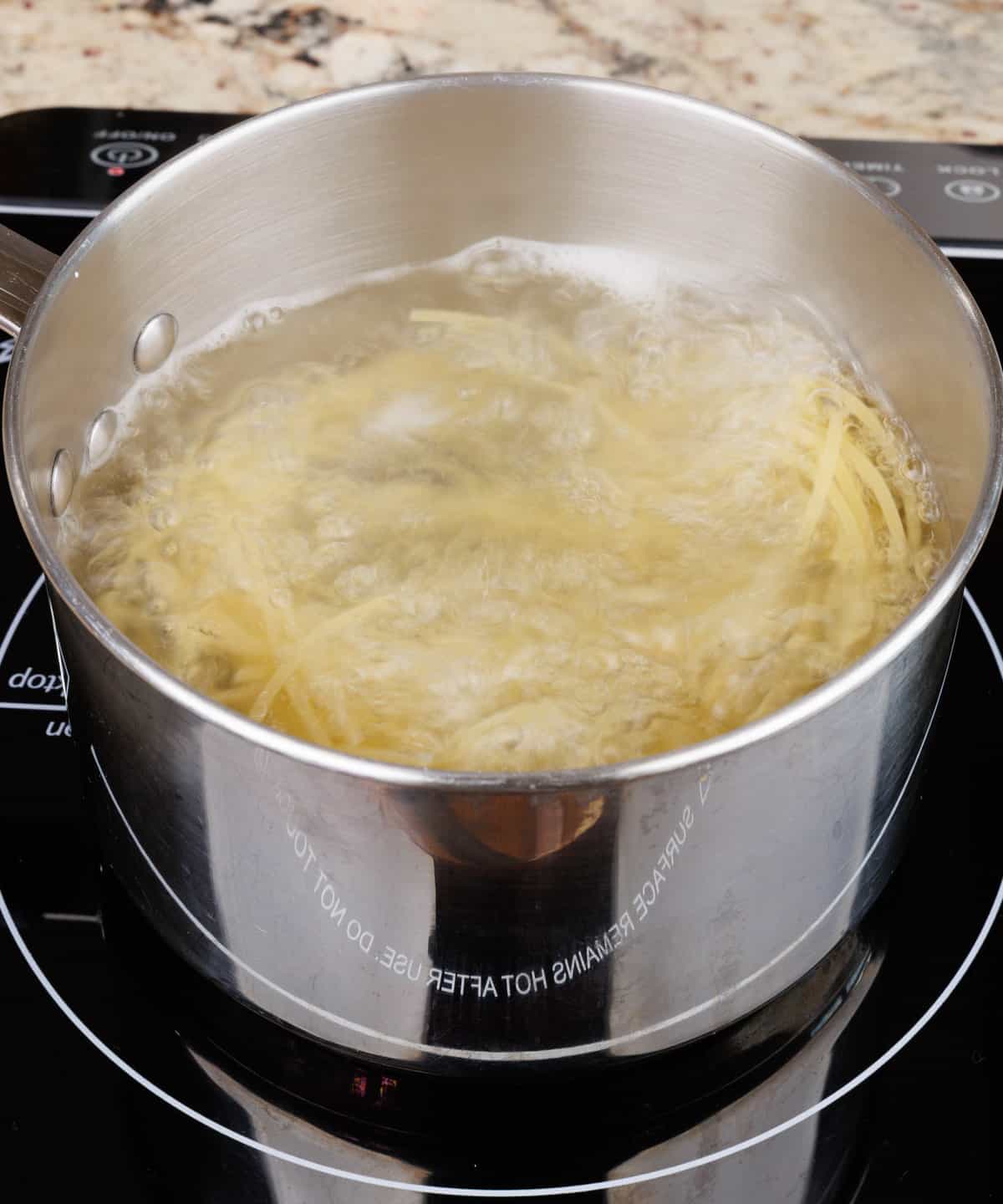 noodles cooking in a pot of boiling water.