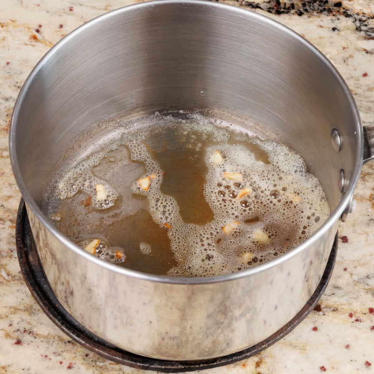 garlic cooking in butter in a small saucepan.