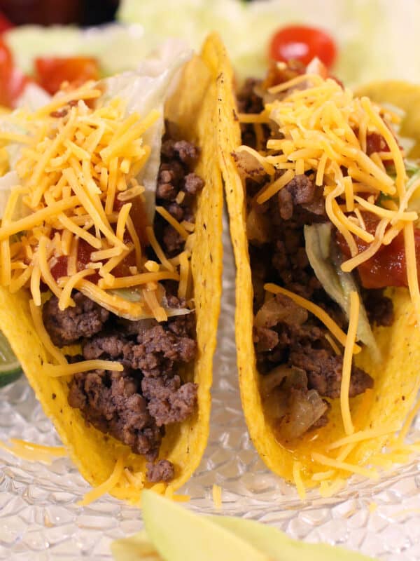 two ground beef tacos on a white plate.