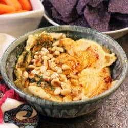 a green bowl filled with hummus.