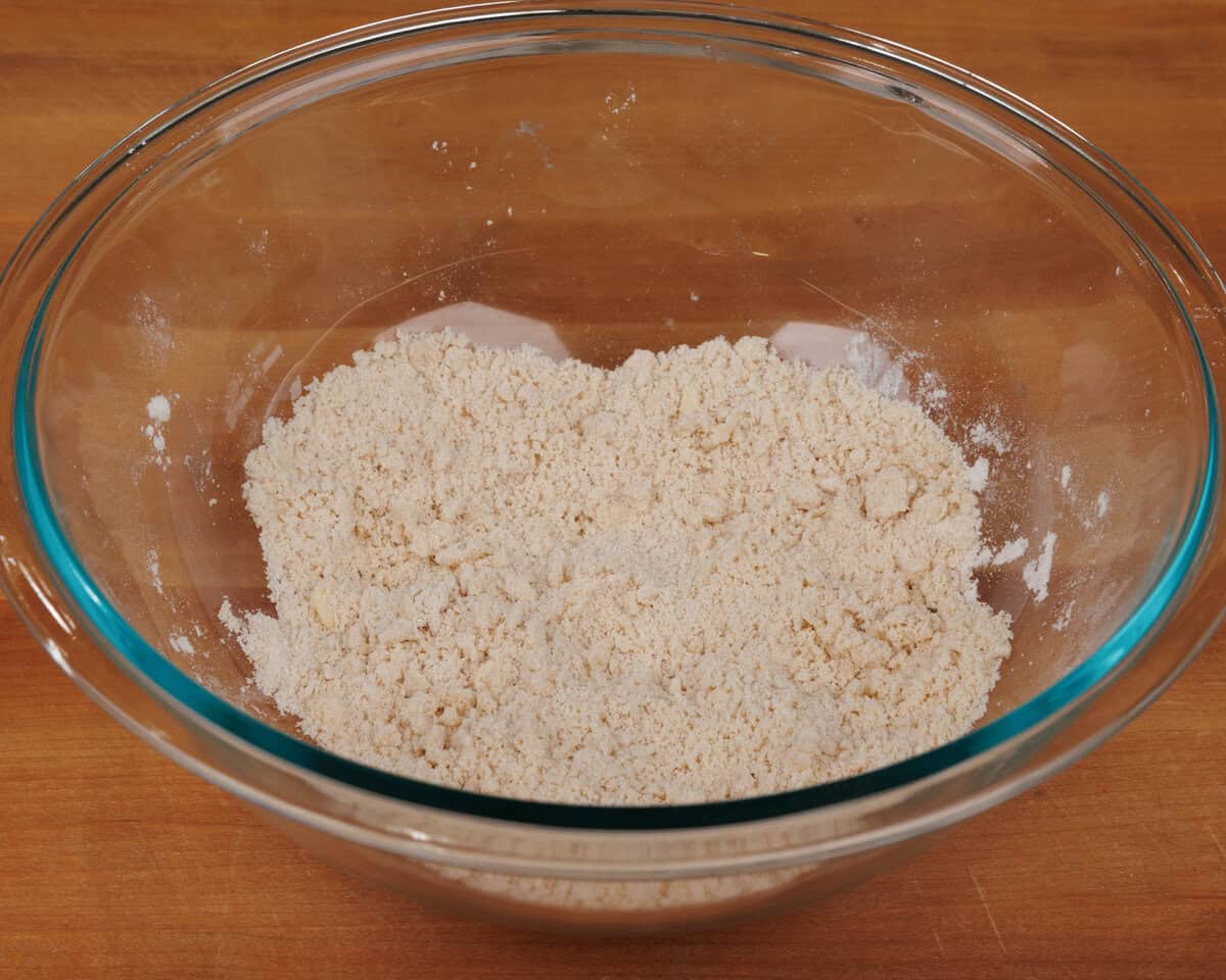 adding butter to biscuit mix in a mixing bowl.