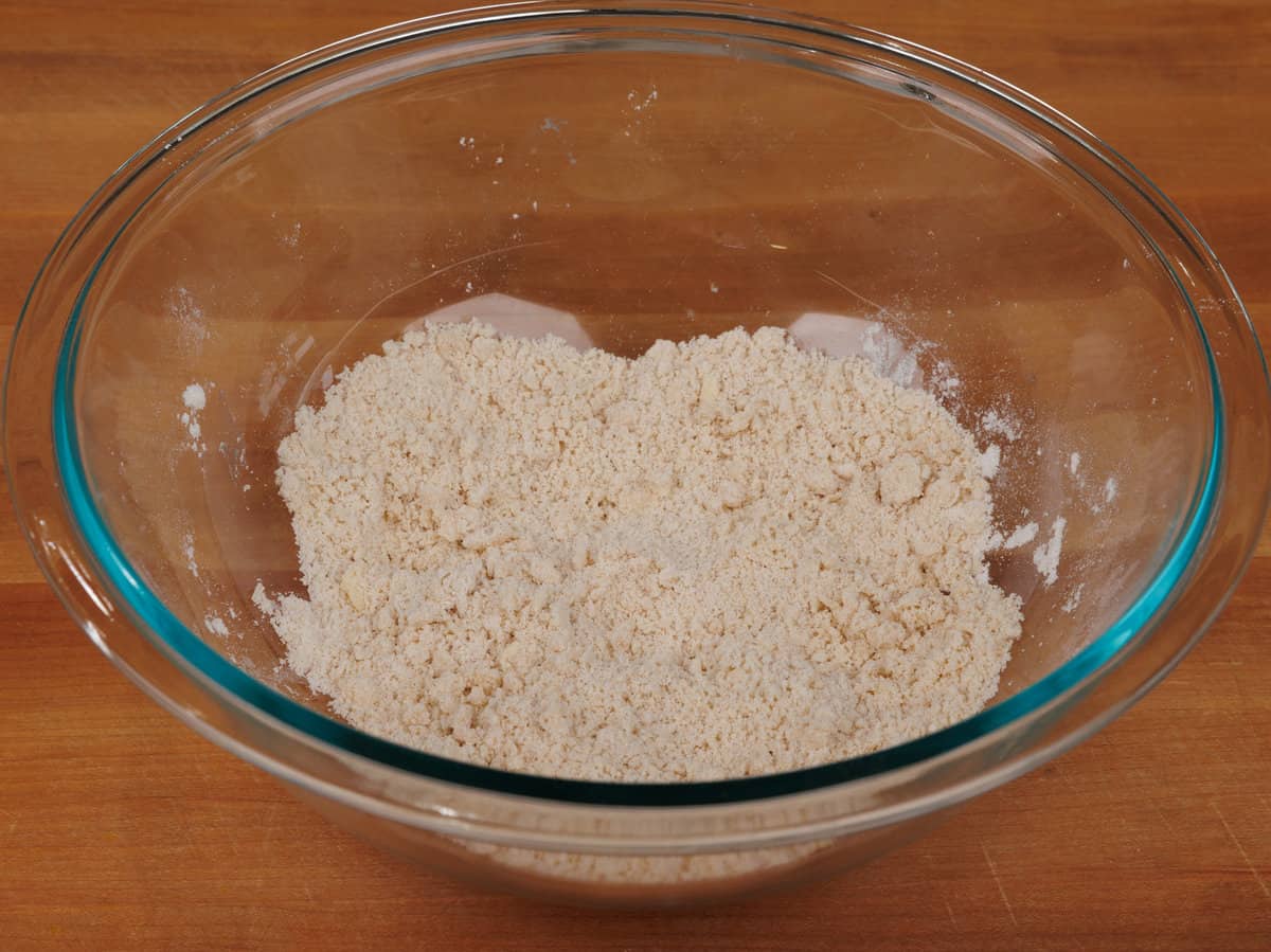 adding butter to biscuit mix in a mixing bowl.