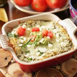 single serving enchiladas verde in a red dish.