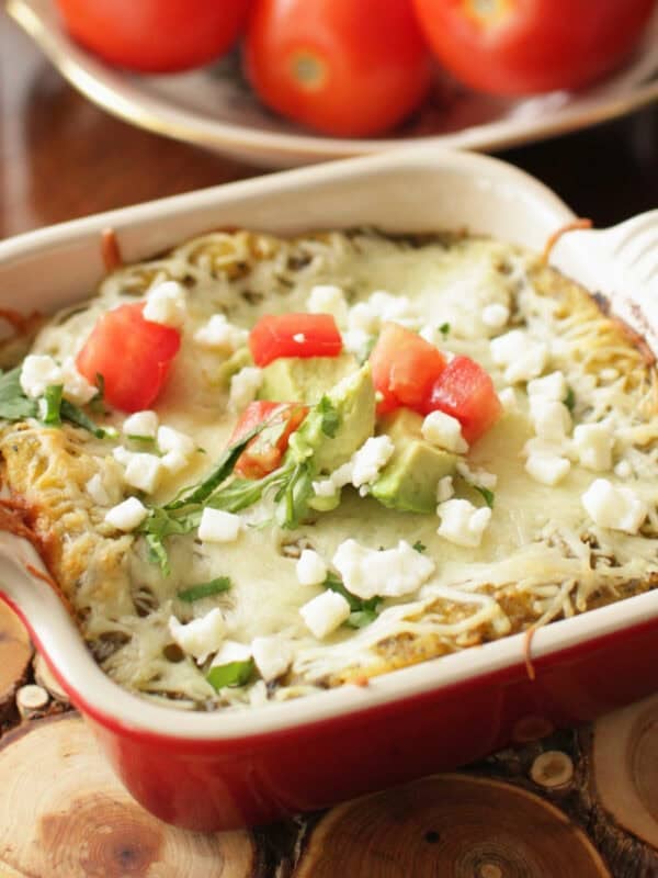 single serving enchiladas verde in a red dish.