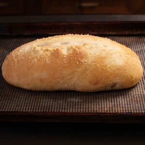 a loaf of french bread on a dark counter.