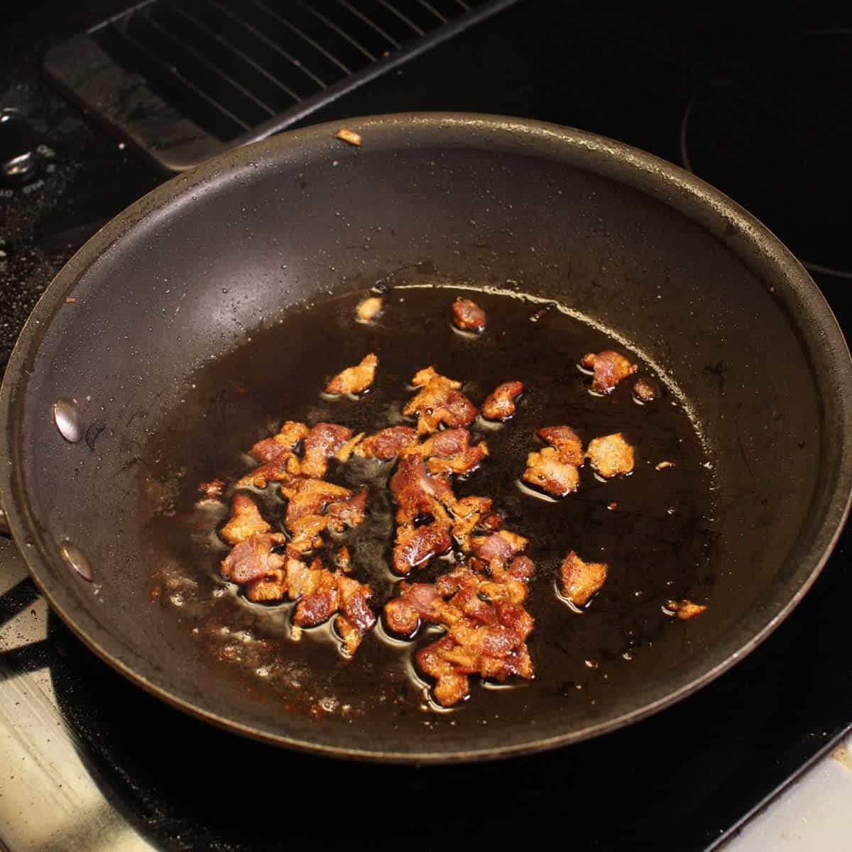 bacon cooking in a frying pan.