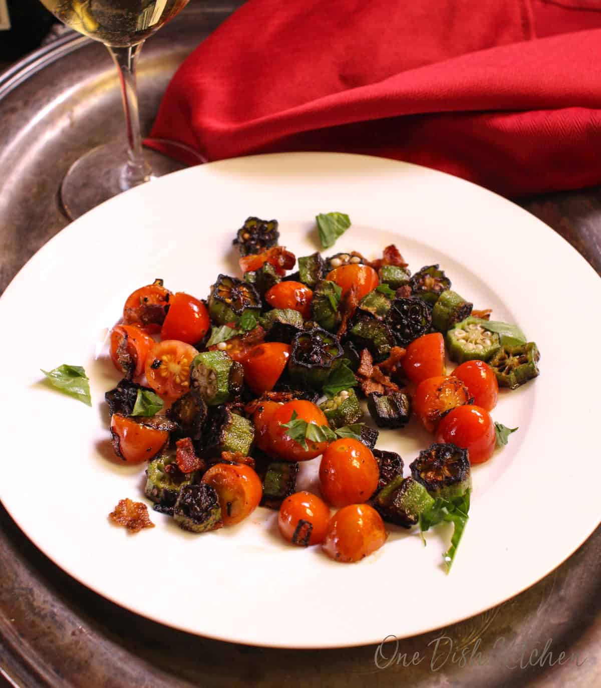 a single serving of pan fried okra and tomatoes on a plate.