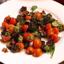 a single serving of pan fried okra and tomatoes on a plate.