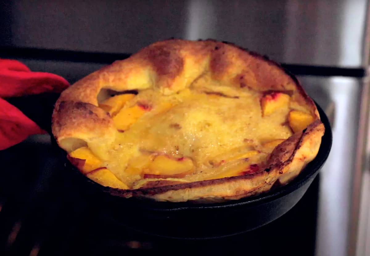 a peach dutch baby out of the oven