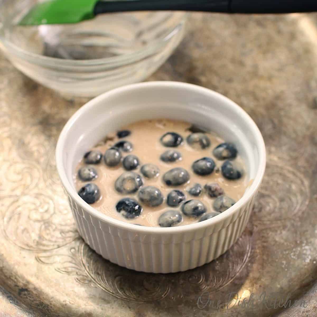 batter poured over a bowl of blueberries.