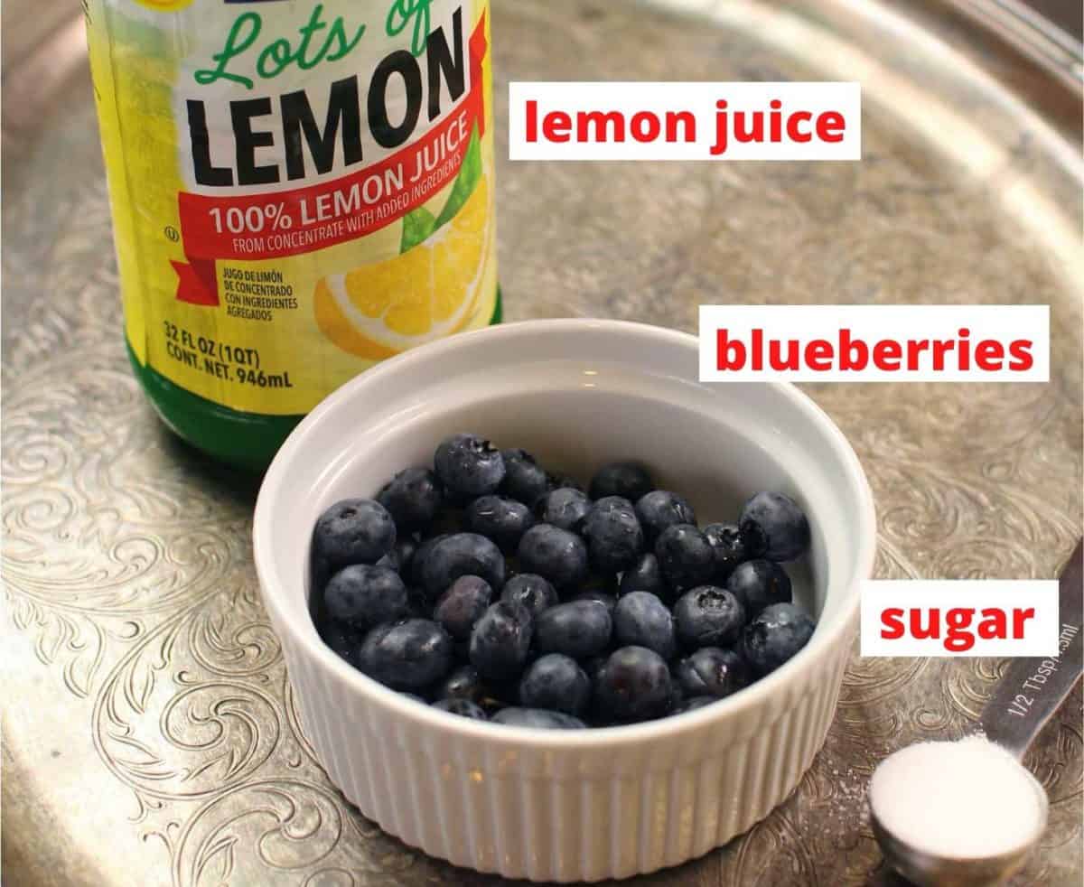 lemon juice, blueberries, and sugar on a tray. The ingredients needed to make cobbler.