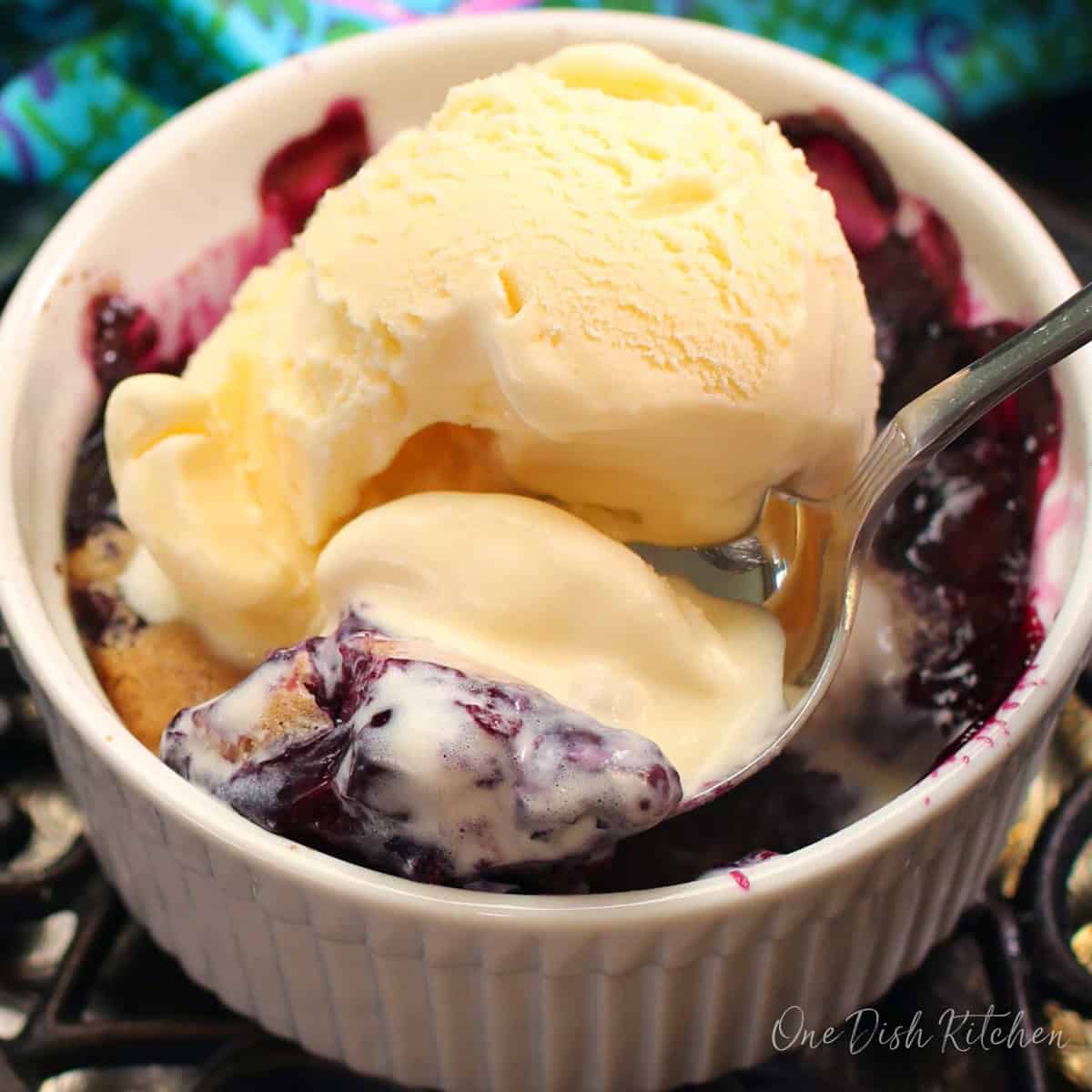 an individual blueberry cobbler with ice cream.
