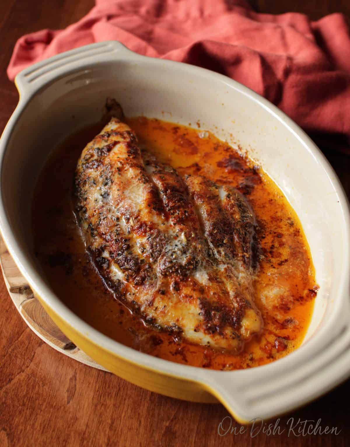 a piece of catfish in a long baking dish.