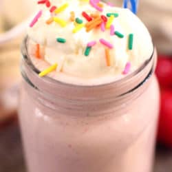 strawberry milkshake with whipped cream and colored sprinkles.