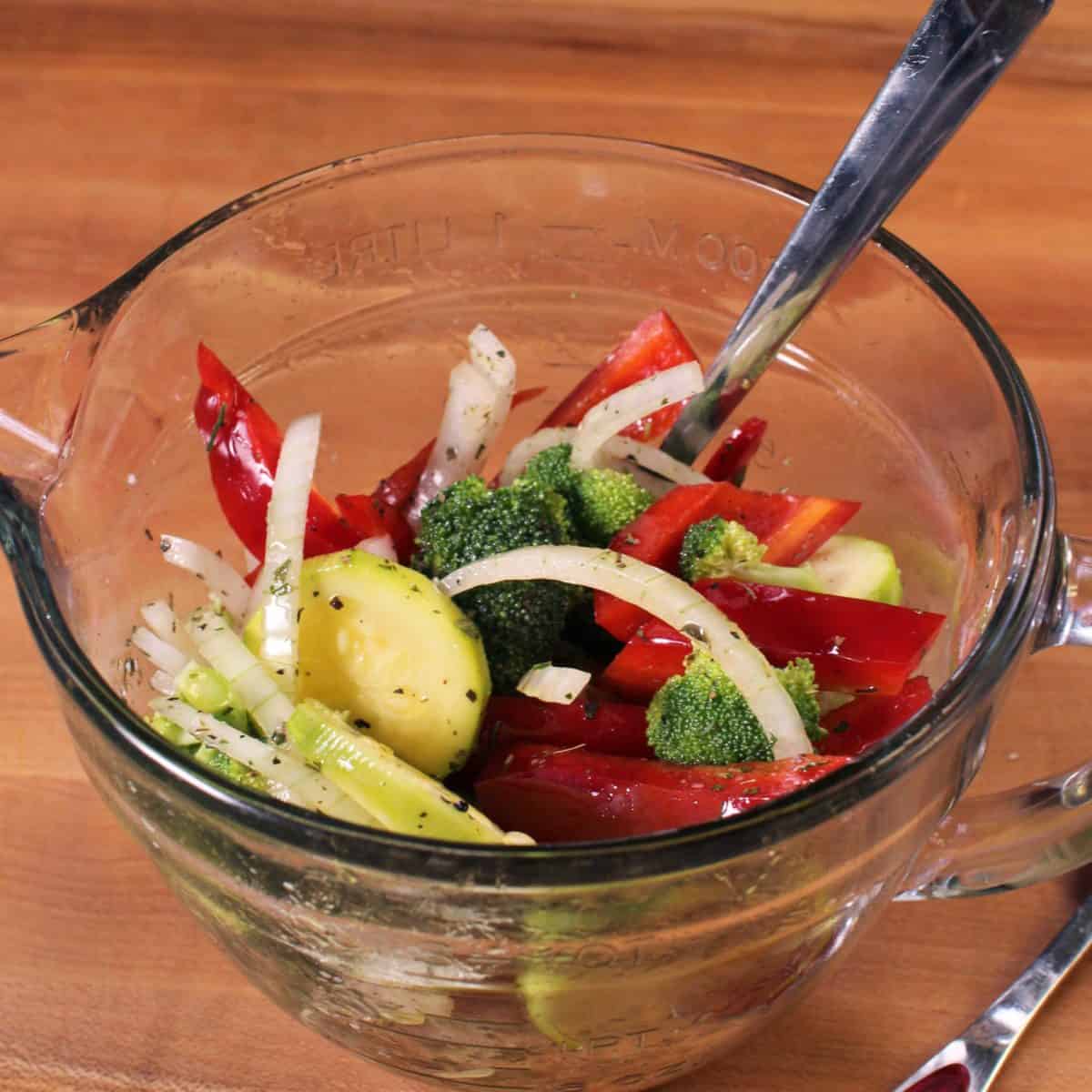a bowl of mixed vegetables on a brown table.
