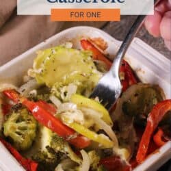 a small vegetable casserole with broccoli and red bell peppers in a white baking dish.