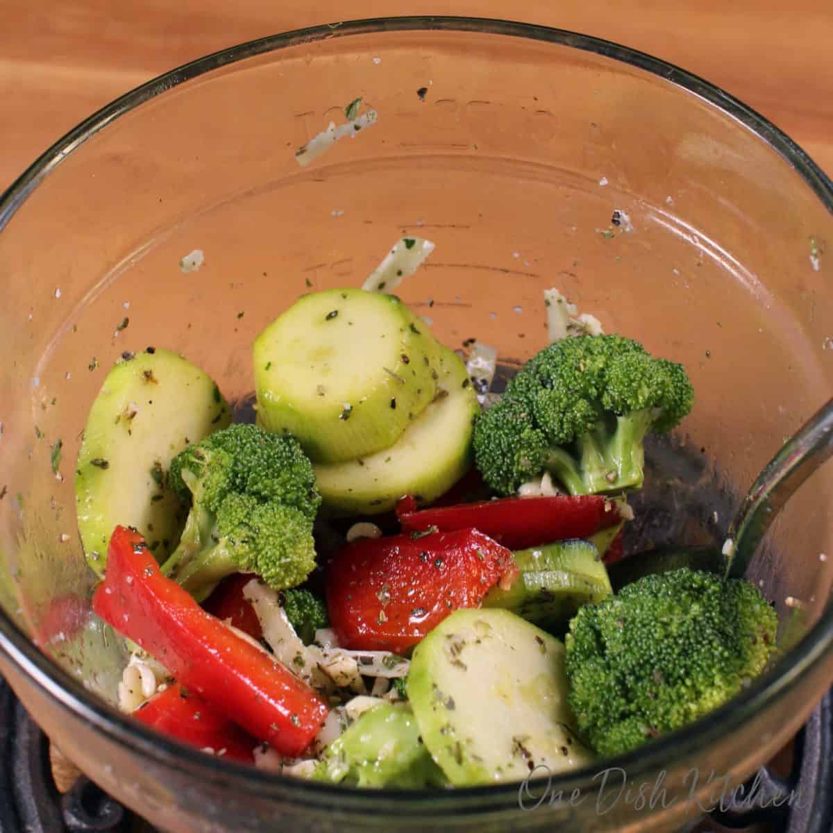 a bowl of mixed vegetables on a brown table.