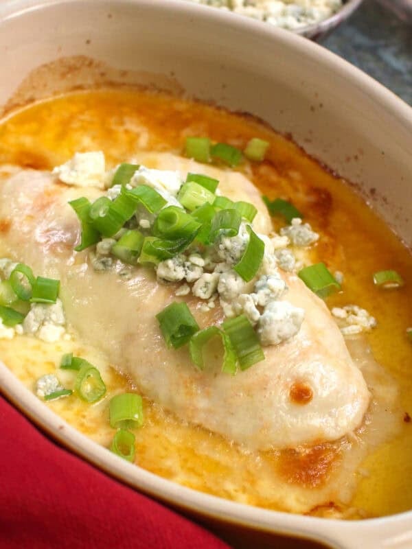 baked buffalo chicken for one person in a baking dish with mozzarella and blue cheese and buffalo sauce.
