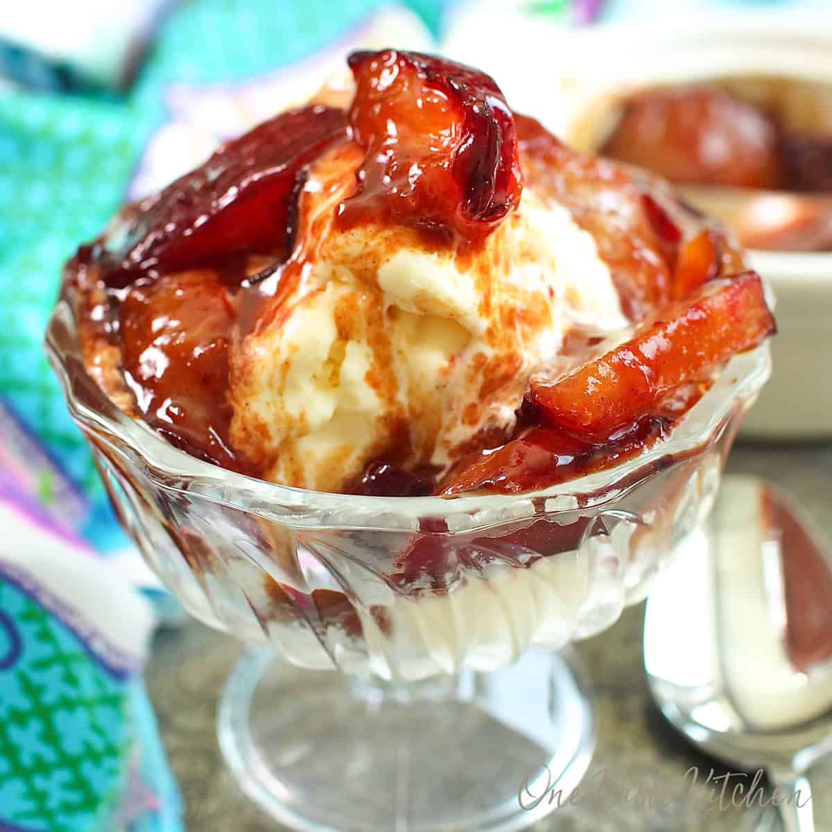 caramelized plums over vanilla ice cream in a dessert dish.