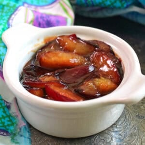 a small batch of caramelized plums in a white bowl.