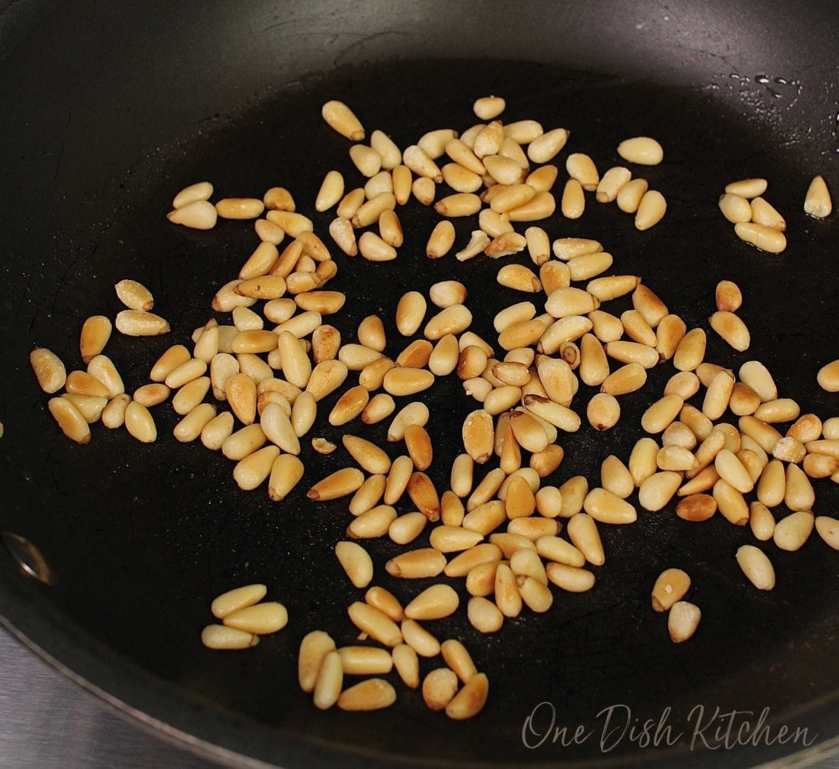 pine nuts toasting in a frying pan.