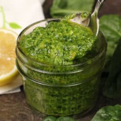 pesto in a small jar next to a half of a lemon.