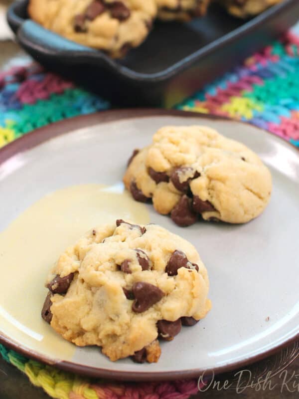two egg free chocolate chip cookies on a blue plate.