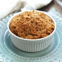 a mini pumpkin coffee cake in a small round baking dish on a green plate