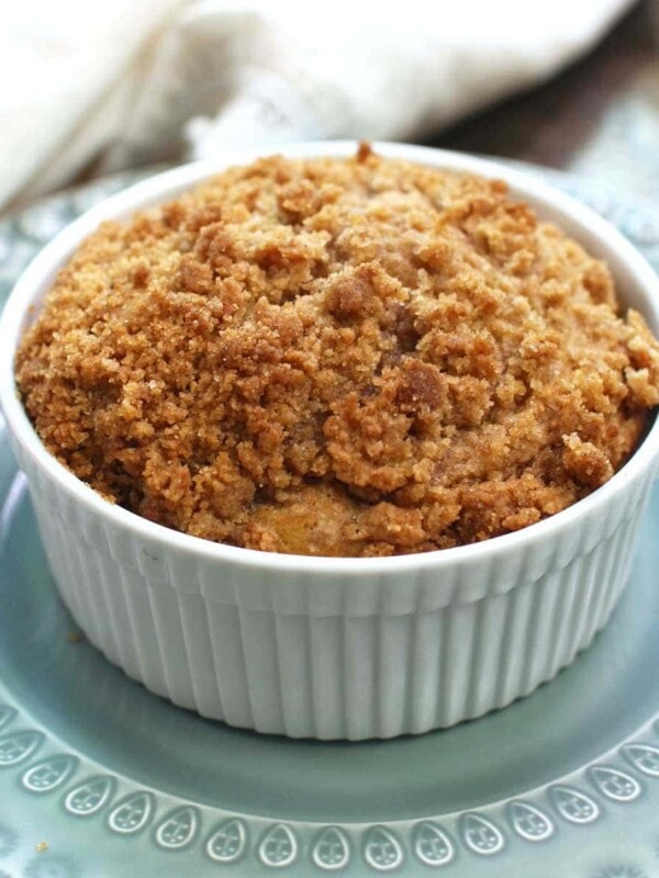 a mini pumpkin coffee cake in a small round baking dish on a green plate
