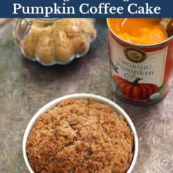 pumpkin coffee cake with streusel topping on a silver tray next to a can of pumpkin puree.