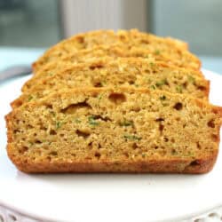 four slices of zucchini bread on a small plate.