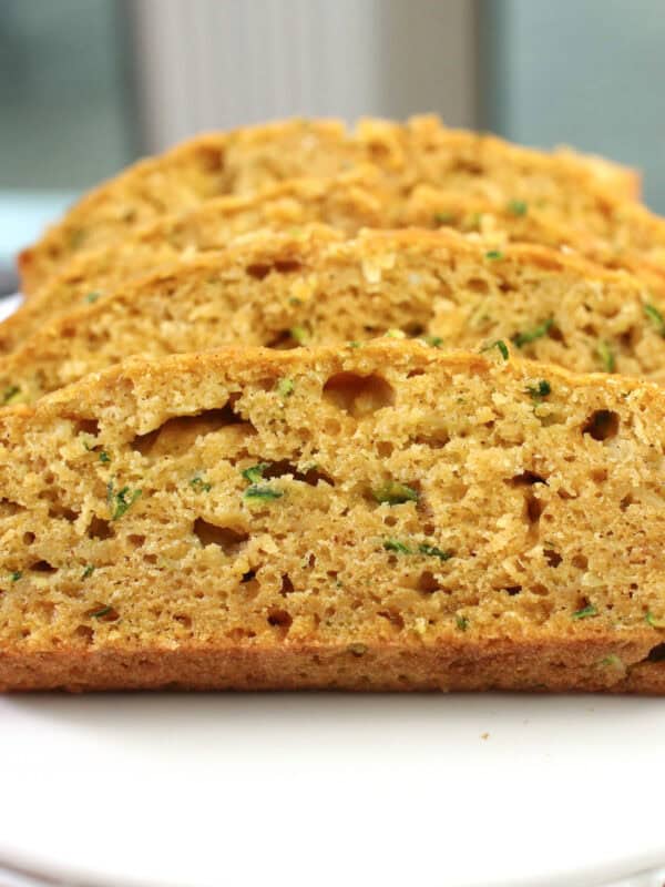 four slices of zucchini bread on a small plate.