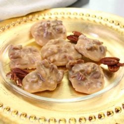 a gold rimmed plate filled with six pecan pralines