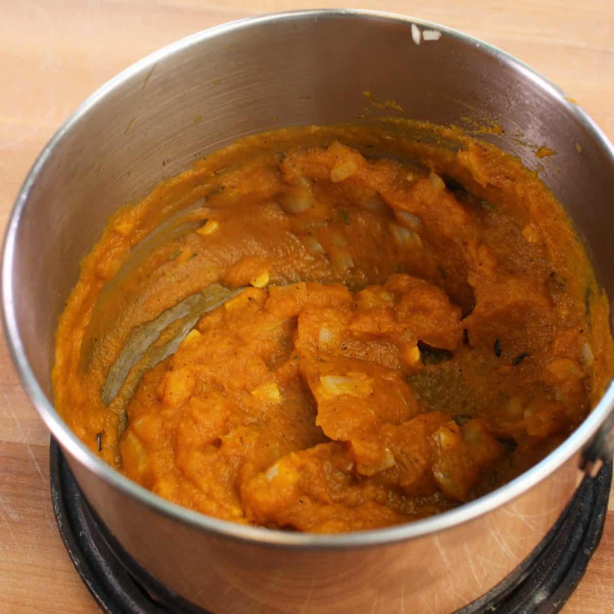 pumpkin puree in a small pot with onions and garlic.