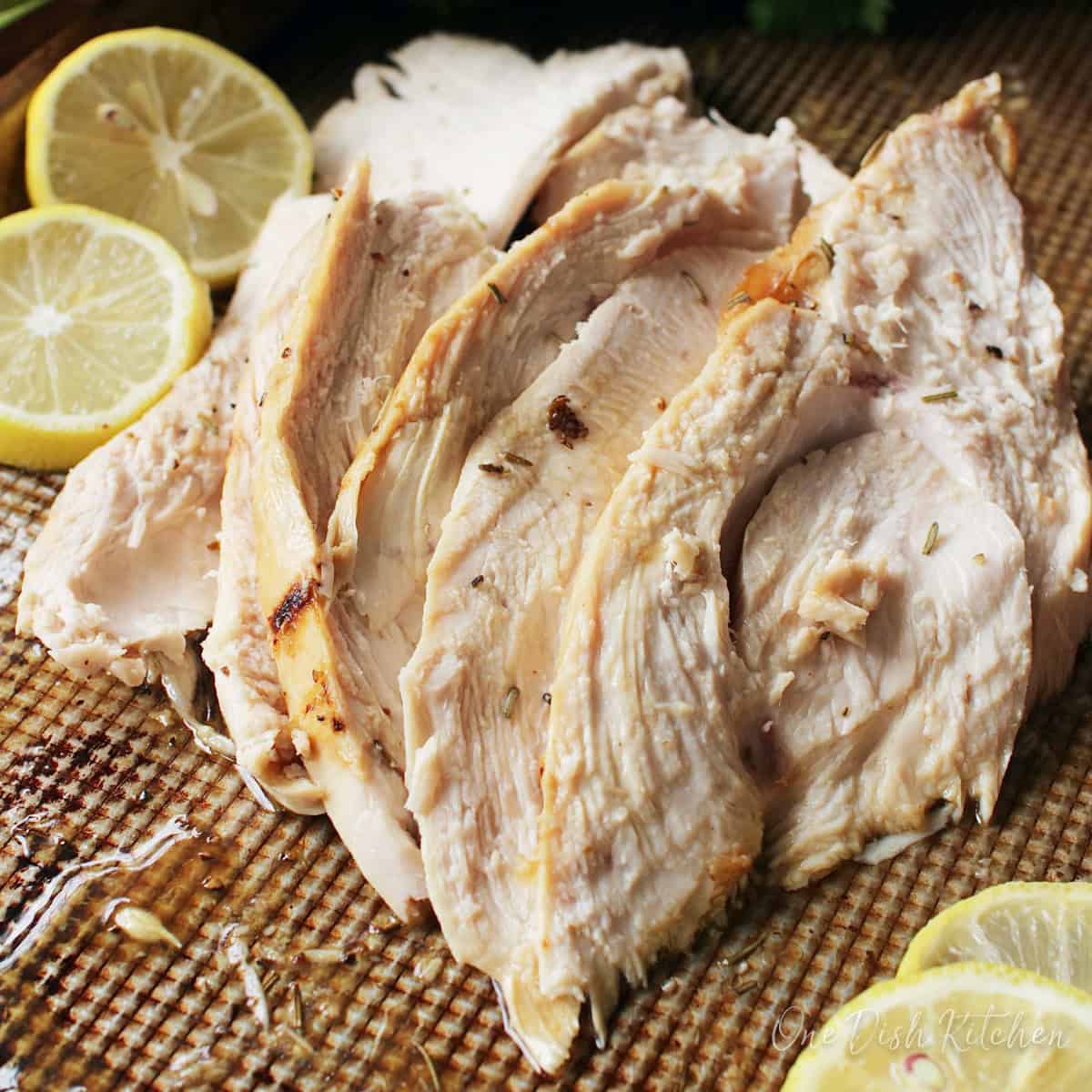 slices of a roast turkey breast on a baking pan.