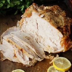 an oven roasted turkey breast on a baking sheet.