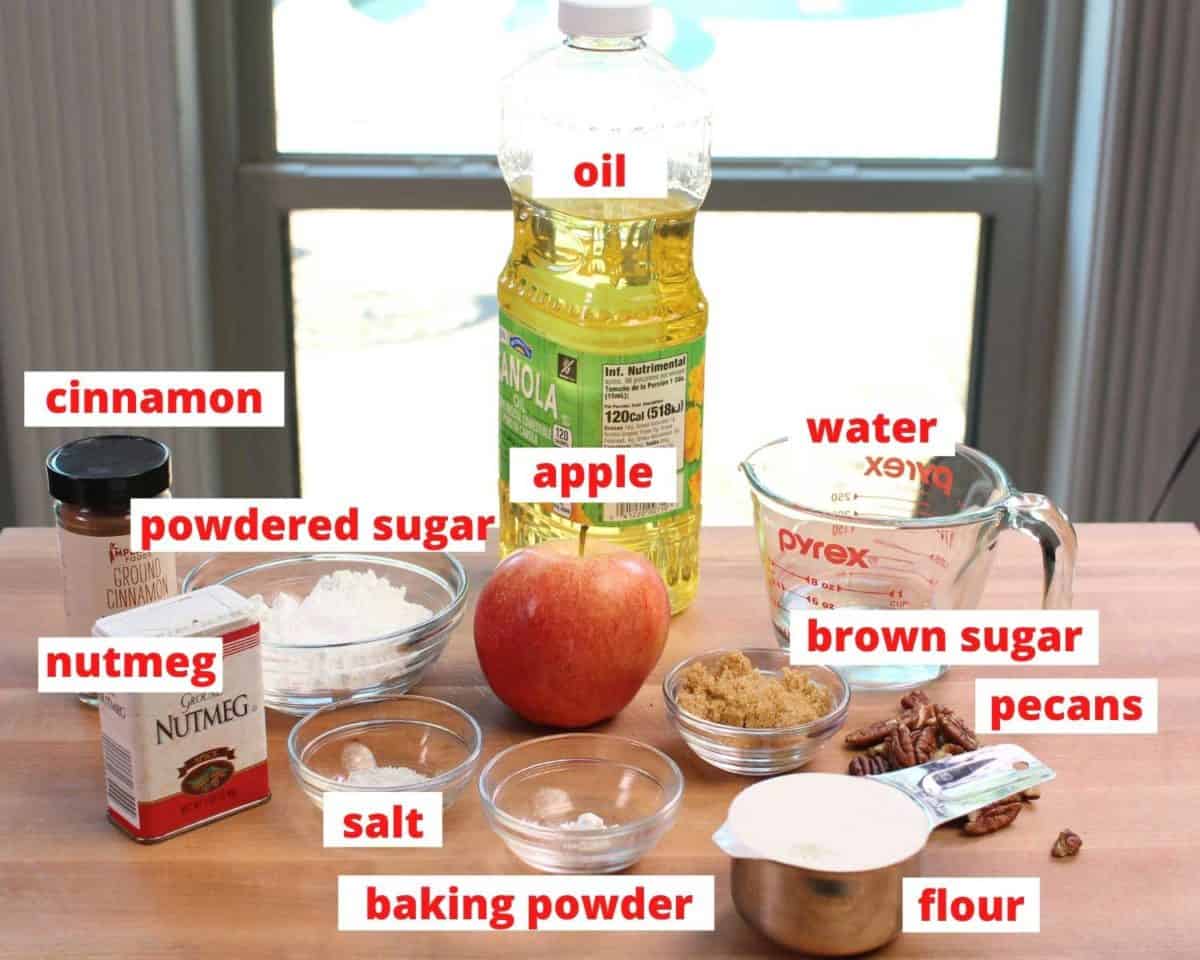 the ingredients needed to make apple fritters labeled and on a brown table.