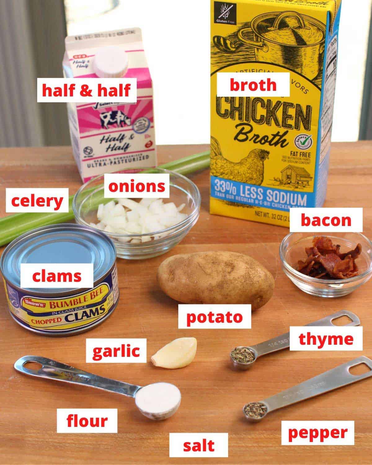 the ingredients needed in new england clam chowder on a brown table labeled.