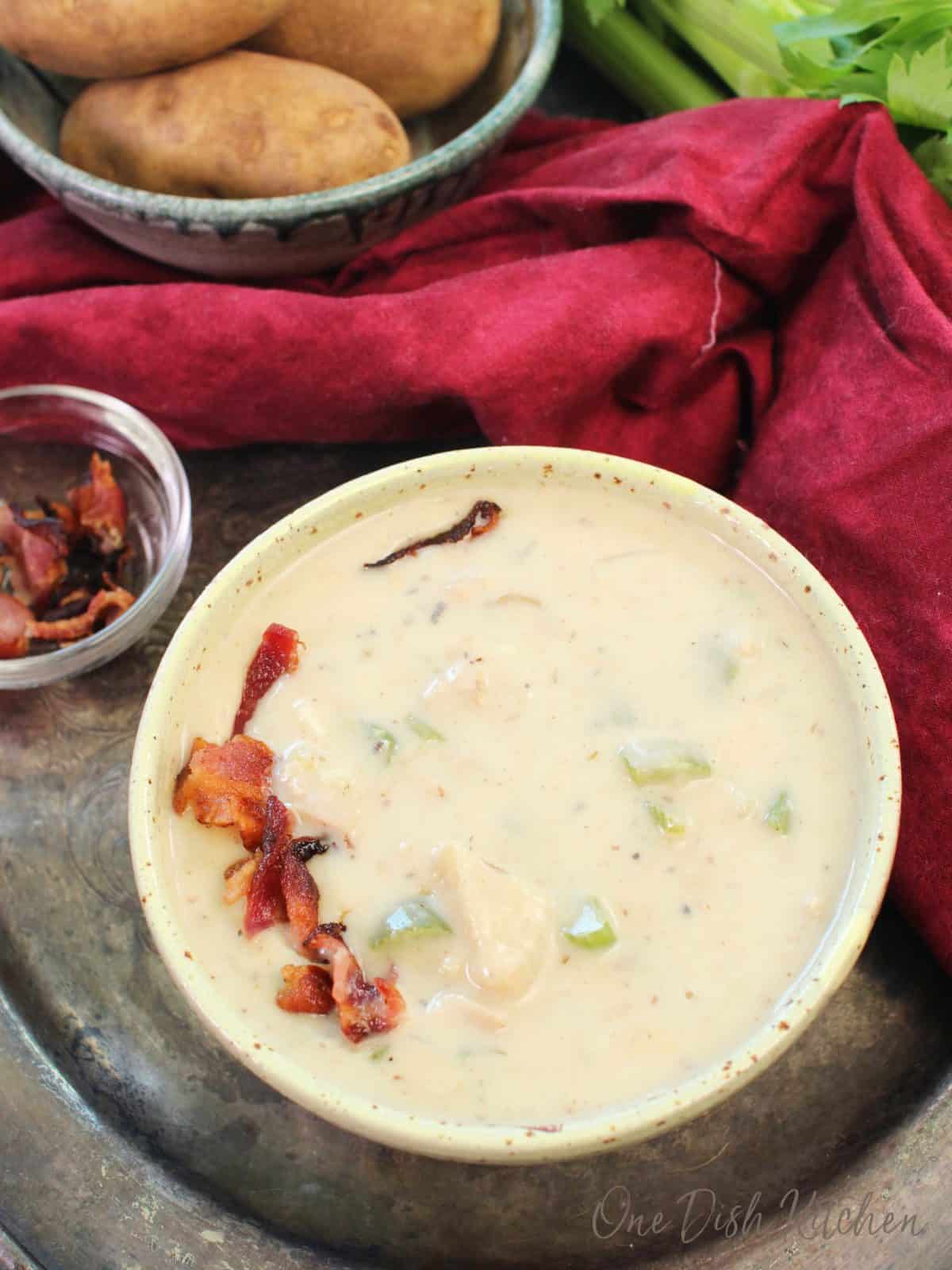 an overhead picture of a bowl of clam chowder topped with cooked bacon.