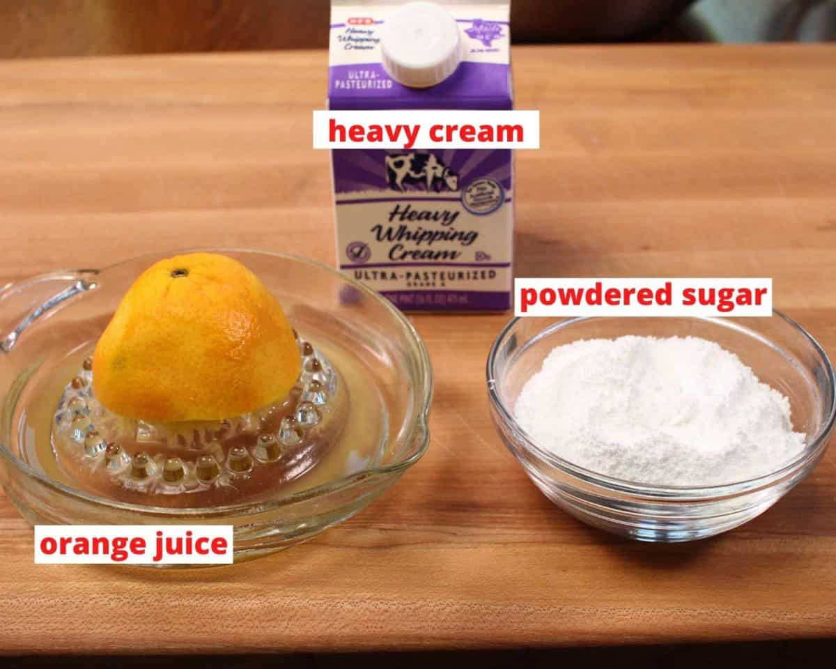 powdered sugar, orange juice, and cream on a brown table.